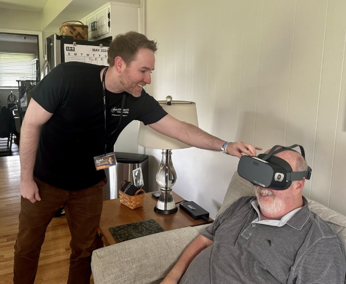 Blake Allee demonstrating Vision Buddy goggles while Bob Butler is wearing them