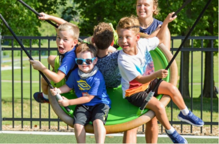 The playground includes a circular web swing. 